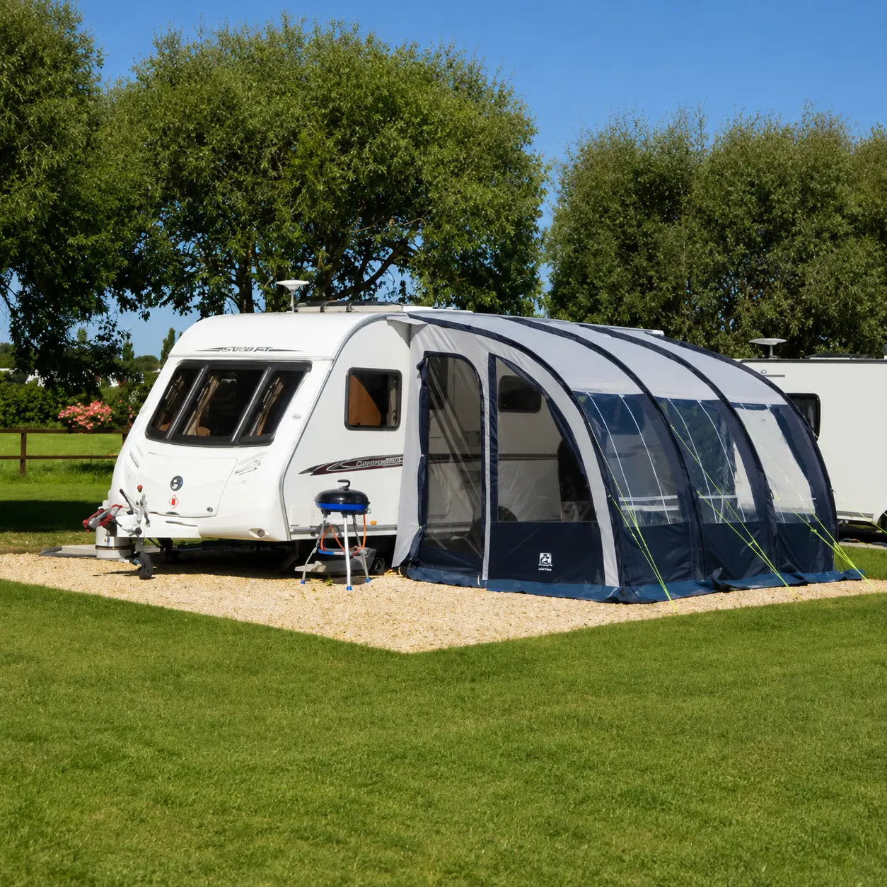 UK touring caravan with awning setup on a peaceful campsite pitch