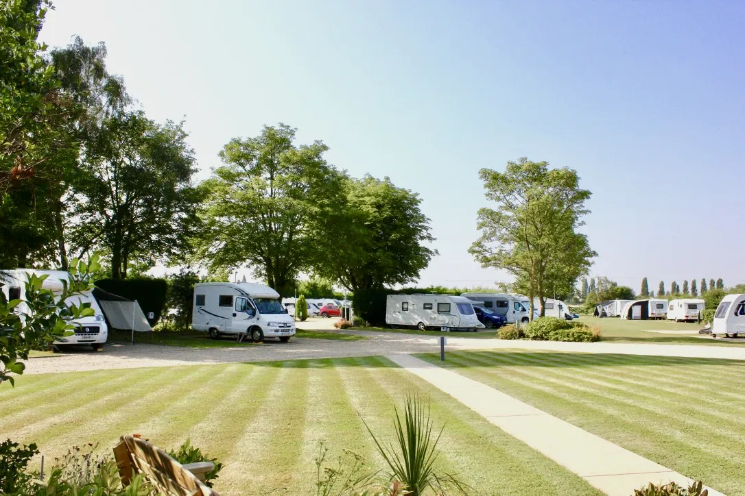 Caravan pitched at Delph Bank Touring Park in Lincolnshire during a sunny summer weekend