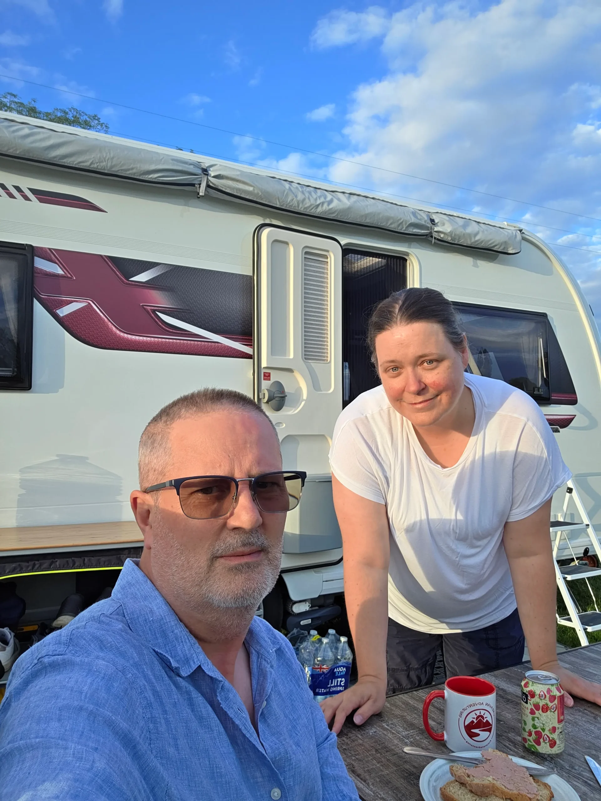 Andy and Amy relaxing beside their Coachman caravan at Ashleigh Farm Caravan and Glamping
